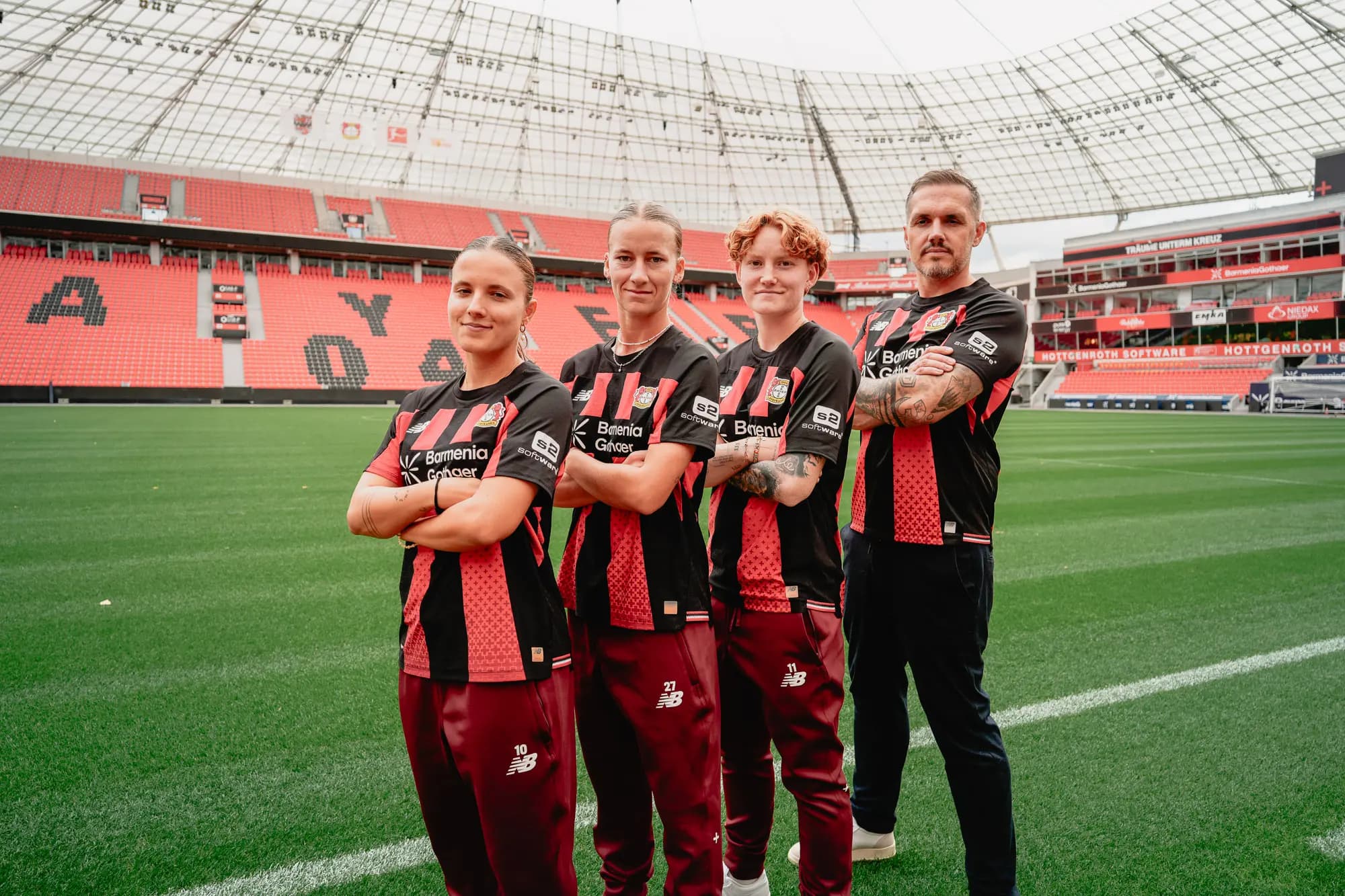 Bayer-04-Spielerinnen und Trainer in Trikots mit s2-Software-Logo in der BayArena
